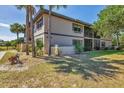 Exterior condo view featuring lush landscaping with palm trees, shrubs, and mature trees at 19505 Quesada Ave # Qq101, Port Charlotte, FL 33948