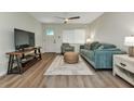 Inviting living room with neutral paint, ceiling fan, plush seating, and wood-look floors throughout at 20238 Banner Ave, Port Charlotte, FL 33952