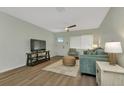 Well-lit living room with wood-look floors, comfortable seating, modern ceiling fan, and front door at 20238 Banner Ave, Port Charlotte, FL 33952