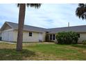 Single story home with a two car garage and a lawn at 21161 Knollwood Ave, Port Charlotte, FL 33952