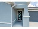Close-up of modern front door showcasing unique design with covered porch at 21310 Quesada Ave, Port Charlotte, FL 33952