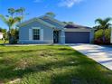 Well-maintained single-story home with a two-car garage and lush green lawn at 21310 Quesada Ave, Port Charlotte, FL 33952