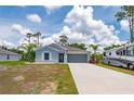 Inviting single-story home with a gray exterior, landscaped front yard and a two-car garage at 21310 Quesada Ave, Port Charlotte, FL 33952
