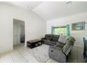 Comfortable living room with tile floors, a sectional couch, and a view to the bathroom at 2336 Redfern St, Port Charlotte, FL 33948