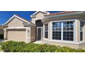 Close-up of a well maintained home with a tile roof, tidy landscaping, and lots of bright windows at 26073 Feathersound Dr, Punta Gorda, FL 33955