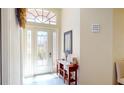 Inviting foyer featuring a decorative front door, mirror, console table, and stylish decor at 26073 Feathersound Dr, Punta Gorda, FL 33955