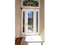 Elegant front door featuring decorative glass panels and sidelights, complemented by a welcome mat at 26073 Feathersound Dr, Punta Gorda, FL 33955