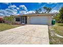 Inviting home featuring a spacious driveway, mature landscaping, and an attached two-car garage for convenience at 3080 Saint James St, Port Charlotte, FL 33952