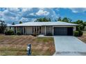 Charming single-story home featuring a metal roof, stone accents, and a convenient attached garage at 543 Mayview Nw Ave, Port Charlotte, FL 33952