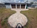Spacious backyard with a decorative brick walkway leading to the house, perfect for entertaining at 635 W Tarpon Nw Blvd, Port Charlotte, FL 33952