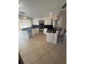 Well-lit kitchen features modern white cabinets, black countertops, and a breakfast bar at 635 W Tarpon Nw Blvd, Port Charlotte, FL 33952