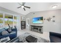 Cozy living room with vaulted ceilings, tile flooring, and a view of the screened-in lanai at 7333 Watson Ln, Port Charlotte, FL 33981
