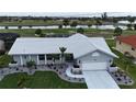 Charming one-story home featuring a well-manicured lawn, mature palm trees and a white tile roof at 745 Monaco Dr, Punta Gorda, FL 33950