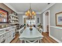Bright dining room with a chandelier, hardwood floors, and a view into the living room at 9239 Impala Cir, Port Charlotte, FL 33981