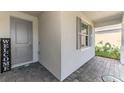 Welcoming front entrance featuring a gray door, decorative welcome sign, and tiled porch at 10995 Pinot Dr, Venice, FL 34293