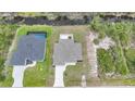 Aerial view of home showcasing its location near a canal and the screened-in pool of neighboring house at 13972 Chesswood Ln, Port Charlotte, FL 33981