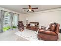 Comfortable living room showcasing leather furniture, a ceiling fan, and sliding glass doors to the outside at 150 Harborside Ave # 306, Punta Gorda, FL 33950