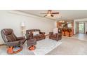 Cozy living room featuring leather seating, a ceiling fan, and an open layout flowing into the kitchen at 150 Harborside Ave # 306, Punta Gorda, FL 33950