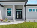 Stunning front entry featuring a double door, decorative windows, and manicured landscaping at 15504 Melport Cir, Port Charlotte, FL 33981
