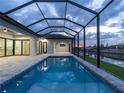 A gorgeous screened-in pool overlooks the canal for amazing views and relaxation at 15504 Melport Cir, Port Charlotte, FL 33981