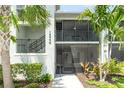 Charming condo exterior with screened-in balcony, lush tropical landscaping, and easy access to stairs at 15990 Grassland Ln # 3024, Punta Gorda, FL 33982