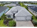 Beautiful aerial view of home, showcasing the three-car garage, paver driveway and landscaping at 17556 Winding Wood Ln, Punta Gorda, FL 33982