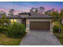 Exterior of a beautiful single-Gathering home at twilight, featuring manicured landscaping and a brick-paved driveway at 1993 E Isles Rd, Port Charlotte, FL 33953