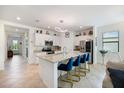 Spacious open-concept kitchen featuring an island with seating, stainless steel appliances, and bright white cabinetry at 1993 E Isles Rd, Port Charlotte, FL 33953
