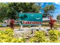 Lakeshore community sign with palm tree design, set amidst lush landscaping and white decorative rocks at 25225 Rampart Blvd # 1603, Punta Gorda, FL 33983