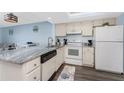 Bright kitchen featuring white cabinets, granite countertops, updated appliances, and an adjacent dining area at 25225 Rampart Blvd # 1603, Punta Gorda, FL 33983