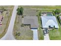 Aerial view of a single Gathering home with a large backyard, pool and driveway in a residential area at 26103 Salonika Ln, Punta Gorda, FL 33983