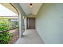 Inviting front porch featuring a tiled walkway and covered entrance with beautiful landscaping at 26103 Salonika Ln, Punta Gorda, FL 33983