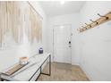 Inviting entryway featuring a marble console table, modern decor, coat hooks, and neutral tile flooring at 27306 Deep Creek Blvd, Punta Gorda, FL 33983