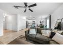 Open-concept living room with tile floors, modern ceiling fan, and seamlessly connecting to the dining and kitchen areas at 27306 Deep Creek Blvd, Punta Gorda, FL 33983