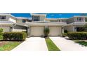 Townhome features a two-car garage and well-maintained landscaping, enhancing its curb appeal at 3412 Grand Vista Ct # 202, Port Charlotte, FL 33953