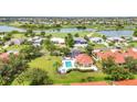 Aerial view showcasing a pool, spa, and nearby homes nestled by a beautiful lake and golf course at 3715 Albacete Cir # 93, Punta Gorda, FL 33950