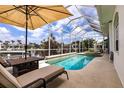 Gorgeous pool area featuring a screened lanai, lounge chairs, and stunning waterfront views at 3907 San Pietro Ct, Punta Gorda, FL 33950