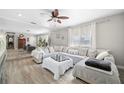 Bright living room featuring a plush sofa, natural light, and modern ceiling fan at 4009 Yucatan Cir, Port Charlotte, FL 33948