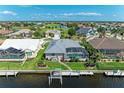 Waterfront home featuring a screened-in pool, boat dock, and lush green lawn at 5010 La Costa Island Ct, Punta Gorda, FL 33950