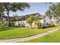 Beautiful home exterior showing lush green lawn, mature shade trees and tropical palm trees at 5301 Linksman Pl, North Port, FL 34287
