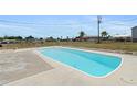 Backyard with a beautiful in-ground pool, surrounded by a concrete patio and chain link fence at 5527 Fairway S Dr, Punta Gorda, FL 33982