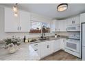 Bright kitchen featuring white cabinetry, granite countertops, and stainless steel appliances at 6336 Drucker Cir, Port Charlotte, FL 33981
