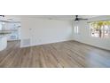 Spacious living room with sleek wood-look floors, ceiling fan, and plenty of natural light at 6336 Drucker Cir, Port Charlotte, FL 33981