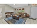 Bright living room with vaulted ceilings, tile flooring, and comfortable couches for relaxing at 6371 Mckinley Ter, Englewood, FL 34224