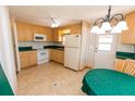 Cozy kitchen featuring wooden cabinets, white appliances, and a tile backsplash at 643 Blackburn Blvd, North Port, FL 34287
