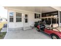 Covered carport area of this home, with a golf cart parked nearby, and the front entry to the home at 713 Riverview Cir, North Port, FL 34287