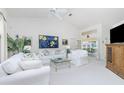 Bright living room featuring vaulted ceilings, white sofas, and an open view to the sunroom and pool at 910 Via Tripoli, Punta Gorda, FL 33950