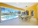 Bright sunroom featuring a screened pool with a view and a table and chairs set for outdoor dining at 910 Via Tripoli, Punta Gorda, FL 33950