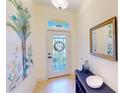 Bright foyer with tiled flooring, decorative glass door, stylish console table, and ample natural light at 10068 Winding River Rd, Punta Gorda, FL 33950