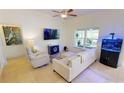Inviting living room featuring neutral tones, a comfortable sofa, an aquarium, and large window at 10068 Winding River Rd, Punta Gorda, FL 33950